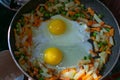 Breakfast for two. Fried eggs with vegetables - shakshuka in a frying pan on a wooden background in rustic style. Flat lay. Top Royalty Free Stock Photo