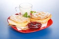 Breakfast: two sour cherry cakes, milk and jam on plate Royalty Free Stock Photo