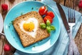 Breakfast on Valentine`s Day - fried eggs and bread in the shape of a heart and fresh vegetables Royalty Free Stock Photo