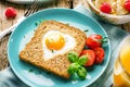 Breakfast on Valentine`s Day - fried eggs and bread in the shape of a heart and fresh vegetables Royalty Free Stock Photo