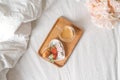 Breakfast for Valentine's Day. Heart shaped white plate with fresh strawberries, cup of coffee, gift and flowers with Royalty Free Stock Photo