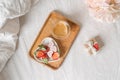 Breakfast for Valentine's Day. Heart shaped white plate with fresh strawberries, cup of coffee, gift and flowers with Royalty Free Stock Photo