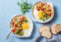 Breakfast vegetable hash with fried eggs on a blue background, top view. Healthy food Royalty Free Stock Photo