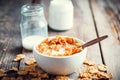 Breakfast wheat flakes in bowl and milk bottles on wooden Royalty Free Stock Photo