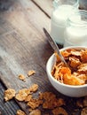 Breakfast wheat flakes in bowl and milk bottles on wooden Royalty Free Stock Photo