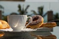 Breakfast in a white cup and chocolate donuts on the glass table in the country house. Royalty Free Stock Photo