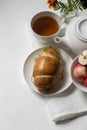 Breakfast on a white plate with vegan sandwich, yogurt, green tea