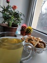 Breakfast by the window. Tea and cookies. Houseplants. Food. Morning magic. Vertical photo on the phone