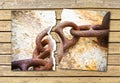 Breaking the chains - concept image with a ripped photo of an old rusty metal chain on wooden background Royalty Free Stock Photo