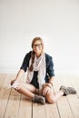 Breaking free and being myself. A conceptual image of a hipster woman sitting on a wooden floor and cutting the strings