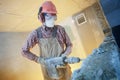 Breaking interior wall. worker with demolition hammer