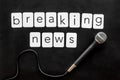 Breaking news concept. Microphone on black background top-down Royalty Free Stock Photo