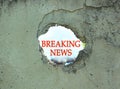 Breaking News sign in concrete fence hole. Infodemic in COVID-19 pandemic. True coronavirus world update