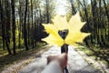 Breaking up couple. concept. Man going away in autumn park through a hole in the form of heart of maple autumn leaf in a woman