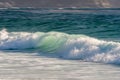 Breaking wave rolling into the sandy beach in Central California Royalty Free Stock Photo