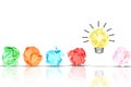 Breakthrough concept with multiple colorful crumpled pieces of paper around a yellow bright light bulb shaped paper on white backg Royalty Free Stock Photo