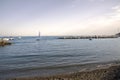 Breakwater and beachfront at sunset. Marine village. Royalty Free Stock Photo