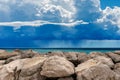 Breakwater with Cumulus Clouds and Torrential Rain over The Sea Royalty Free Stock Photo