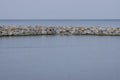 The breakwater in the form of a strip of stones stretches out into the sea Royalty Free Stock Photo