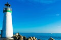 Breakwater lighthouse stands on jetty at California Pacific Ocean coast under blue sky at the daytime