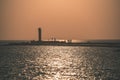 breakwater in the sea with red lighthouse at the end - vintage r Royalty Free Stock Photo