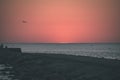 breakwater in the sea with red lighthouse at the end - vintage r Royalty Free Stock Photo