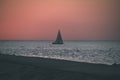 breakwater in the sea with red lighthouse at the end - vintage r Royalty Free Stock Photo