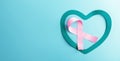 Breast Cancer Awareness Campaign Concept. Women Healthcare. Close up of a Pink Ribbon Lying inside a Teal Heart