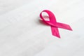 Breast cancer awareness concept. Pink ribbon on a wooden table.