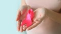 Breast Cancer Awareness and October Pink day. Pregnant woman in pink T- shirt with hand holding Pink Ribbon Royalty Free Stock Photo