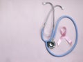 Breast cancer awareness pink ribbon with doctor stethoscope on pink background, october symbol, healthcare and medicine concept Royalty Free Stock Photo