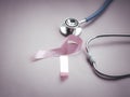 Breast cancer awareness pink ribbon with doctor stethoscope on pink background, october symbol, healthcare and medicine concept Royalty Free Stock Photo