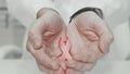 Breast cancer awareness pink ribbon in the hands of a doctor Royalty Free Stock Photo