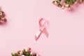 Breast Cancer Awareness symbol - pink satin ribbon with roses on pink background Royalty Free Stock Photo