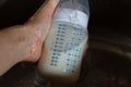 Breast milk in bottle thawing under running water