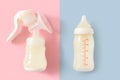 Breast pump and bottle of milk for newborn baby over pink and blue pastel colors background. Maternity and baby care concept. Girl Royalty Free Stock Photo