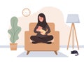 Breastfeeding concept. Young islamic mother sitting on armchair and nursing newborn baby. Natural feeding, happy Royalty Free Stock Photo