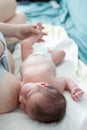 Breastfeeding, mother giving a baby the breast, infant laying on white bedsheet in bed Royalty Free Stock Photo