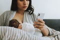 Breastfeeding mother using a smartphone