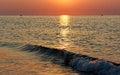 Motion blur wave by golden-orange sky and sea at sunset