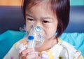 Breathing through a steam nebulizer. Illness girl admitted in hospital.