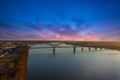 A breathtaking aerial shot of the running waters of the Mississippi river with powerful clouds and a stunning sunset with a bridge