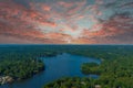 A breathtaking aerial shot of the still blue waters of the lake with vast miles of lush green trees with homes and boat docks Royalty Free Stock Photo