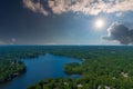 A breathtaking aerial shot of the still blue waters of the lake with vast miles of lush green trees with homes and boat docks Royalty Free Stock Photo