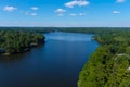 A breathtaking aerial shot of the still blue waters of the lake with vast miles of lush green trees with homes and boat docks Royalty Free Stock Photo