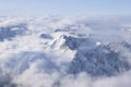 Beautiful aerial view of snow capped mountain peaks above clouds Royalty Free Stock Photo