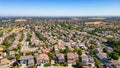 A breathtaking aerial view of Antioch, California: houses nestled amidst verdant hills, crisscrossed by meandering streets, all