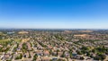 A breathtaking aerial view of Antioch, California: houses nestled amidst verdant hills, crisscrossed by meandering streets, all