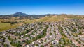 A breathtaking aerial view of Antioch, California: houses nestled amidst verdant hills, crisscrossed by meandering streets, all