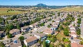 A breathtaking aerial view of Antioch, California: houses nestled amidst verdant hills, crisscrossed by meandering streets, all